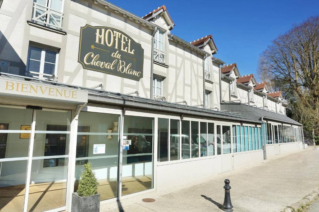 Vista exterior do Hôtel Le Cheval Blanc, um dos hotéis perto da Disney Paris, com grandes janelas, letreiro e uma faixa de boas-vindas 'Bienvenue' por cima da entrada.
