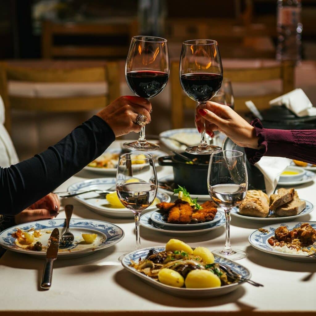 Mesa do restaurante Adega São Nicolau, no Porto, com vários pratos tradicionais e vinho